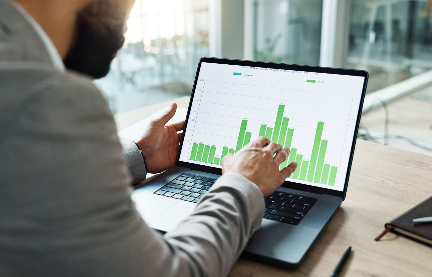 man-analyzing-green-graph-on-laptop-at-desk-2026-09-22-05-42-24-utc Program Management
